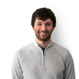 Man wearing grey sweater, with short black hair and facial hair